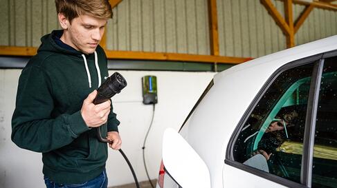 Mann beim E-Auto laden