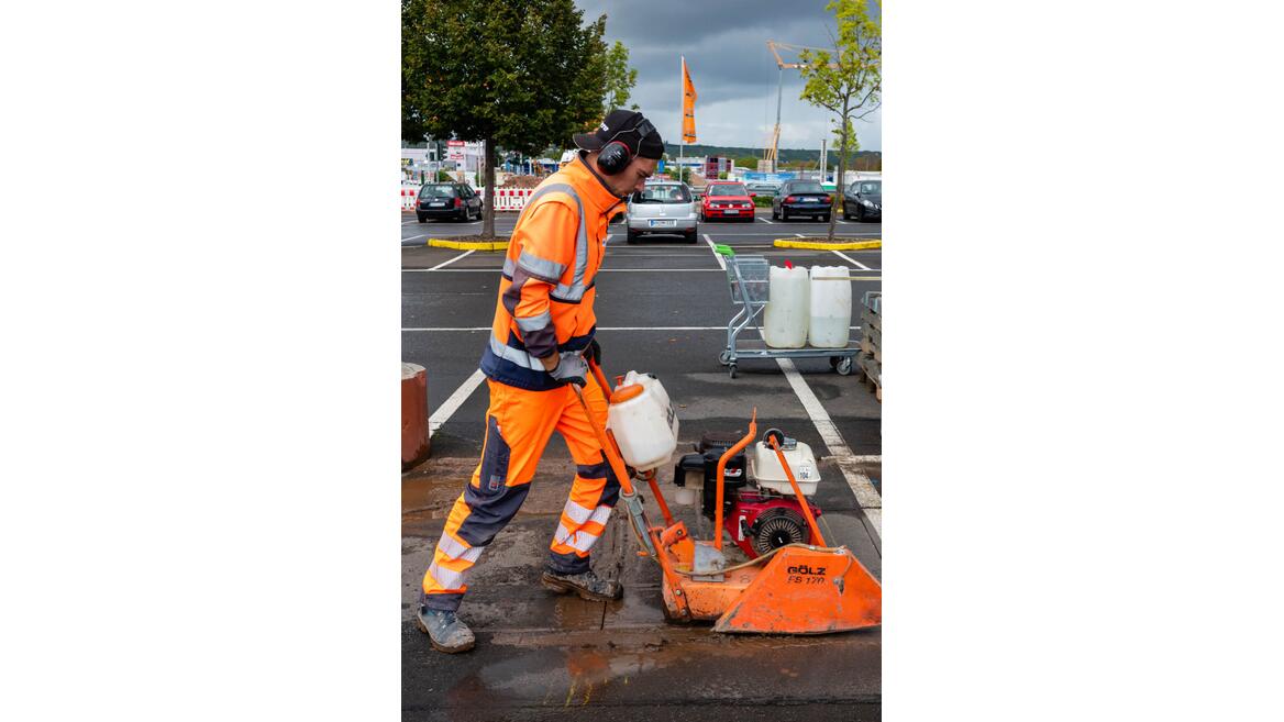Für den Aufbau eines Ladeparks wird der Asphalt mit einem Fugenschneider aufgeschnitten.
