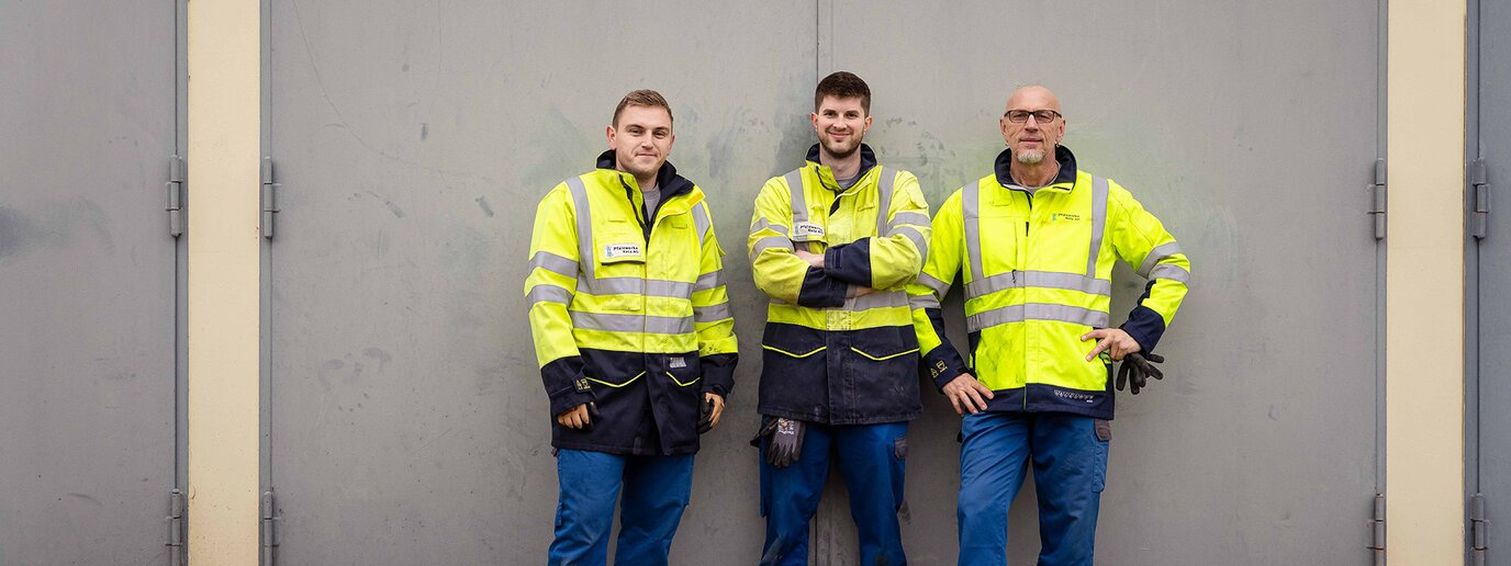 Team draußen stehend an der Wand